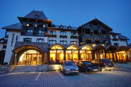 a large building with cars parked in front of it at Hanul Bran in Bran