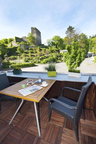 a table and chairs on a balcony with a view of a castle at Ferienwohnungen "am Fürstenweg" in Neuwied