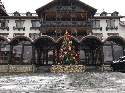 a building with a christmas tree in front of it at Hanul Bran in Bran