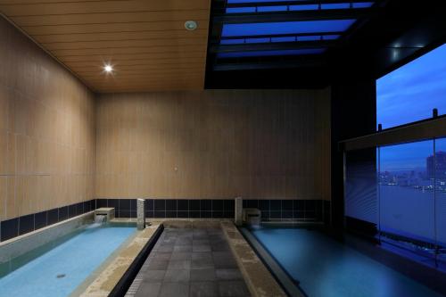 a swimming pool in a building with a large window at THE SINGULARI HOTEL & SKYSPA at UNIVERSAL STUDIOS JAPAN in Osaka