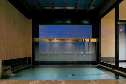 a swimming pool with a view of the city from a building at THE SINGULARI HOTEL & SKYSPA at UNIVERSAL STUDIOS JAPAN in Osaka