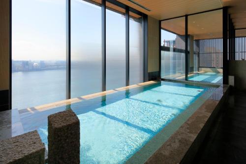 a swimming pool in a building with a view of the water at THE SINGULARI HOTEL & SKYSPA at UNIVERSAL STUDIOS JAPAN in Osaka
