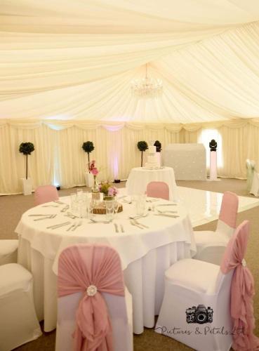 a white tent with a table and chairs in a room at Rettendon Lodge in Battlesbridge