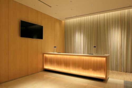 a lobby with a flat screen tv on a wall at THE SINGULARI HOTEL & SKYSPA at UNIVERSAL STUDIOS JAPAN in Osaka