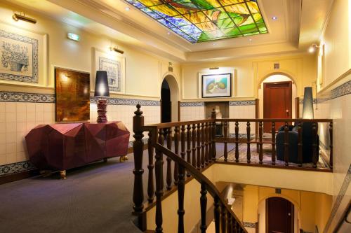 a hallway with a staircase with a stained glass ceiling at Hotel Internacional Porto in Porto