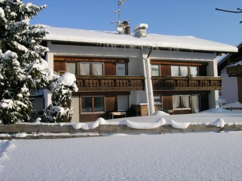 a house covered in snow with a fence at Haus Sorgschrofen in Pfronten