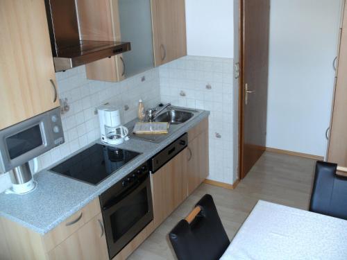 a small kitchen with a sink and a microwave at Pension Waldhof in Koppl