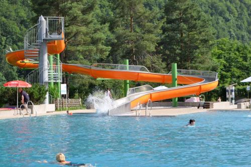 a swimming pool with a slide in the water at Haus Treffer in Kirchdorf in Tirol