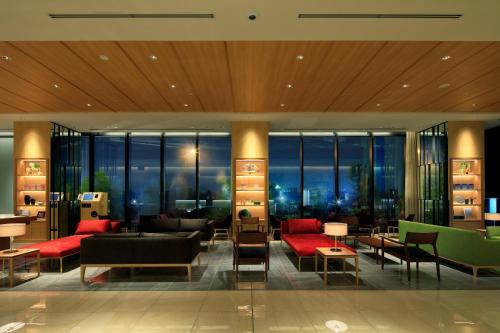 a lobby with couches and tables in a building at THE SINGULARI HOTEL & SKYSPA at UNIVERSAL STUDIOS JAPAN in Osaka