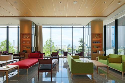 a lobby with colorful chairs and tables and windows at THE SINGULARI HOTEL & SKYSPA at UNIVERSAL STUDIOS JAPAN in Osaka