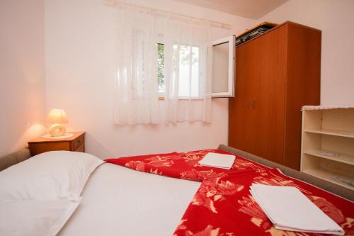 a bedroom with a bed with a red blanket and a window at Apartments Mio in Brist