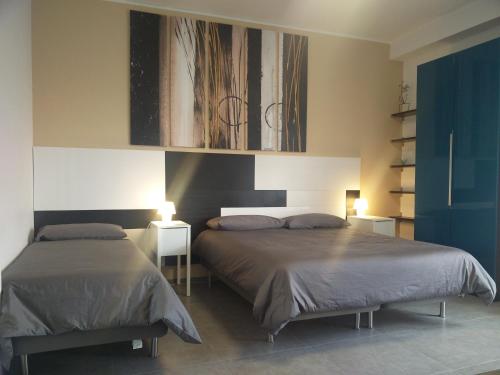 1 dormitorio con 2 camas y 2 mesas con lámparas en B&B Via Roma 15, en Acquaviva delle Fonti