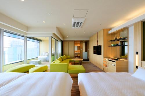 a hotel room with two beds and a living room at THE SINGULARI HOTEL & SKYSPA at UNIVERSAL STUDIOS JAPAN in Osaka
