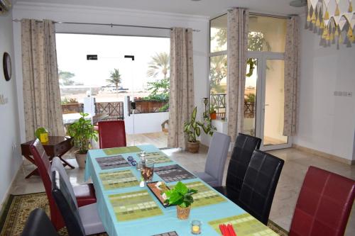 a dining room with a blue table and chairs at Lana Villa in Muscat