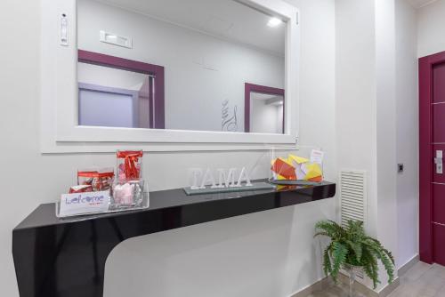 a bathroom with a black counter and a mirror at Tama Rooms in Rome