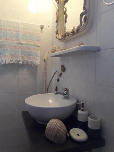 a bathroom with a sink and a mirror at House On The Wave in Marathokampos