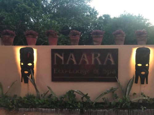 a sign for a restaurant with plants on a wall at Naara Eco Lodge & Spa in Chidenguele
