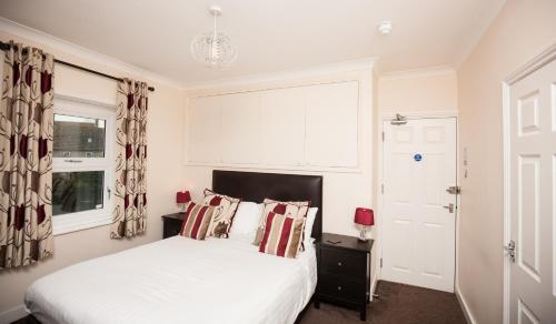 a bedroom with a white bed and a window at Bridge Hotel Brandon in Brandon