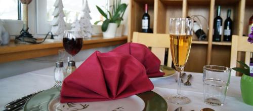 - une table avec deux verres de vin et des serviettes dans l'établissement Hotel - Restaurant - Café Forsthaus Lahnquelle, à Netphen