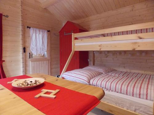 a bedroom with a bunk bed and a table with a tray at Weiherhütte in Glan-Münchweiler