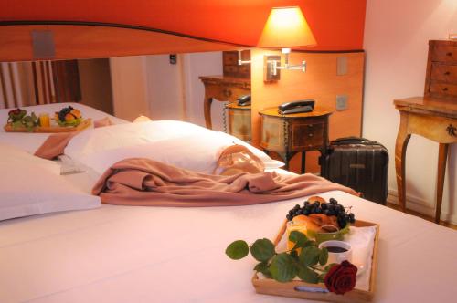 a bed with a blanket and a tray of fruit at Hotel Eden Montmartre in Paris