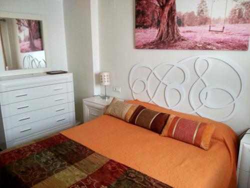 a bedroom with a large bed with an orange blanket at Gran Plaza in Roquetas de Mar