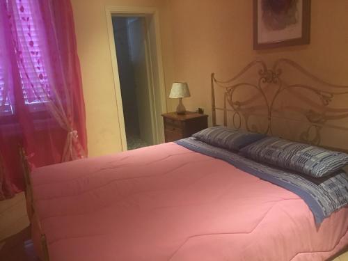 エンポリにあるLa locandaのベッドルーム1室(ベッド1台、ランプ、窓付)