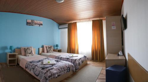 een slaapkamer met 2 bedden en een raam bij City Comfort Villa in Boekarest