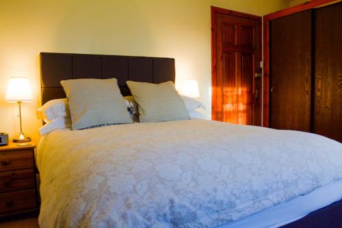 a bedroom with a large white bed with two pillows at Clarke Cottage Guest House in Dunfermline