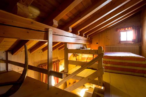 an attic room with a bunk bed and a window at Hotel Lyshaus in Gressoney-Saint-Jean