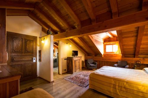 a bedroom with a bed in a room with wooden ceilings at Hotel Lyshaus in Gressoney-Saint-Jean