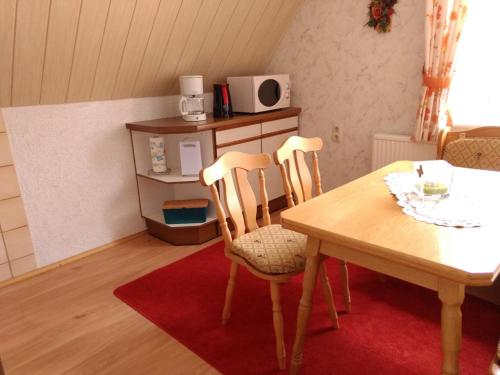 クロルト・アルテンベルクにあるFerienwohnung Petzoldのテーブルと椅子2脚、キッチンが備わる客室です。