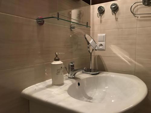 a bathroom sink with a soap dispenser on it at Renovated apartment in Opole in Opole