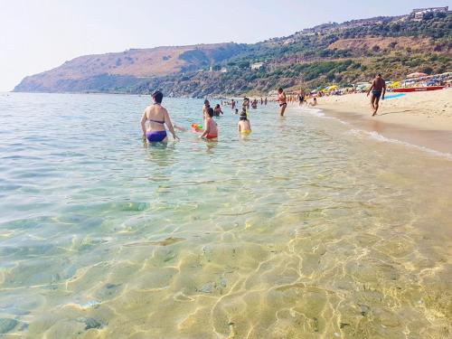 a group of people in the water at the beach at Casa del Sole in Nicotera Marina