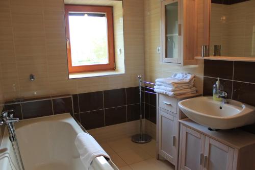 a bathroom with a bath tub and a sink at Promenáda Lipno in Lipno nad Vltavou