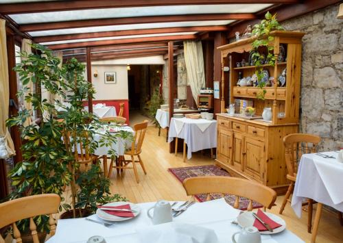 鄧弗姆林的住宿－Clarke Cottage Guest House，一间在房间内配有桌椅的餐厅