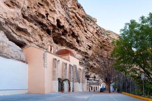 a church in front of a mountain next to a street at Casa Rural La Herradura del río Júcar in Jorquera