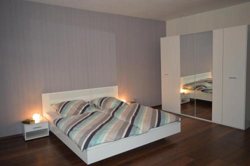 a bedroom with a large bed and a mirror at Ferienwohnung "Haus 10" in Essen
