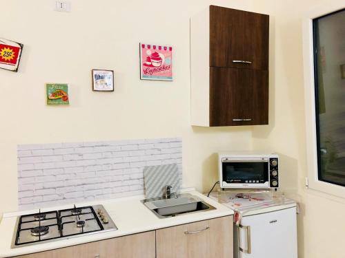 Una pequeña cocina con fregadero y microondas. en Sogni D'oro, en Bari
