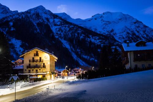 a building in front of a mountain at night at Hotel Lyshaus in Gressoney-Saint-Jean
