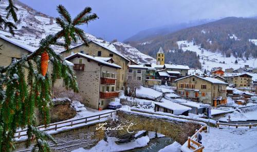 a village in the snow with a bridge and buildings at Casa dello Sciatore in Bormio