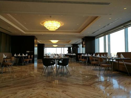 a dining room with tables and chairs and a chandelier at Braira Al Wezarat in Riyadh