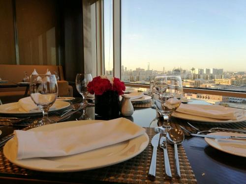a table with plates and glasses and a view of the city at Braira Al Wezarat in Riyadh