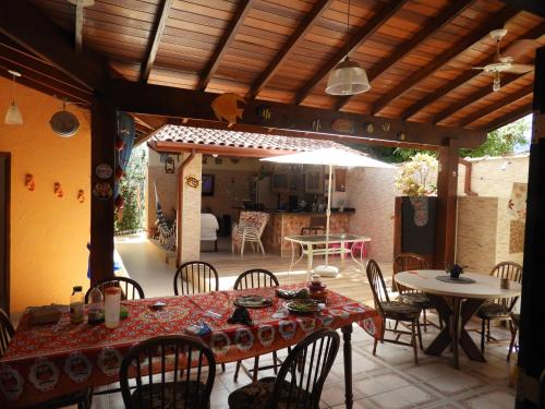 eine Terrasse mit einem Tisch, Stühlen und einem Sonnenschirm in der Unterkunft ACIOLY'S BEACH HOUSE in Caraguatatuba