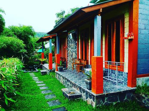 a house with orange and blue paint on it at Black Lava Hostel and Lodge in Kintamani