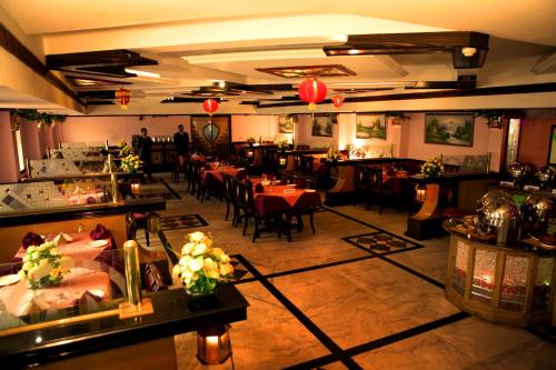 The Surya, Cochin في أنغمالي: غرفة طعام مع طاولات وكراسي في مطعم
