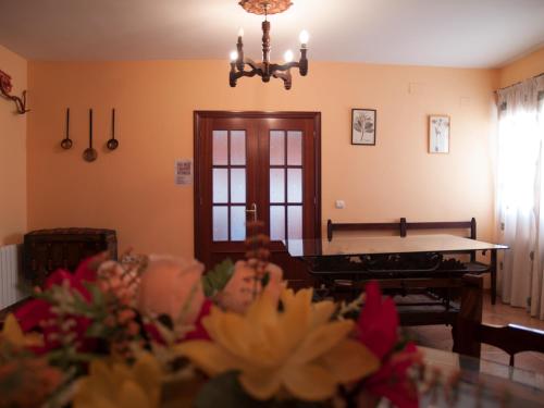 uma sala de estar com mesa de pingue-pongue e flores em Casa Rural El Botánico em Casatejada