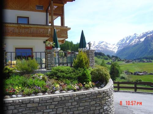 a house with a retaining wall and a garden at Hotel Kranebitt in Val di Vizze