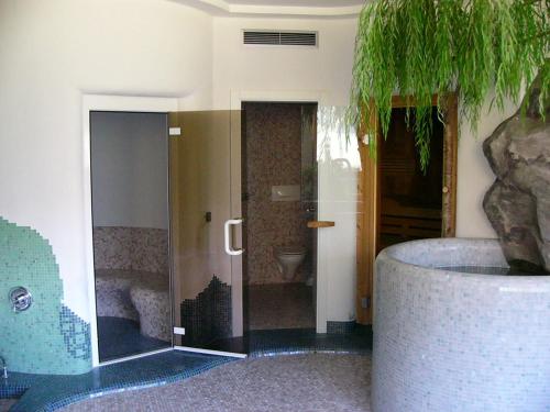 a bathroom with a tub and a shower with a sink at Hotel Kranebitt in Val di Vizze