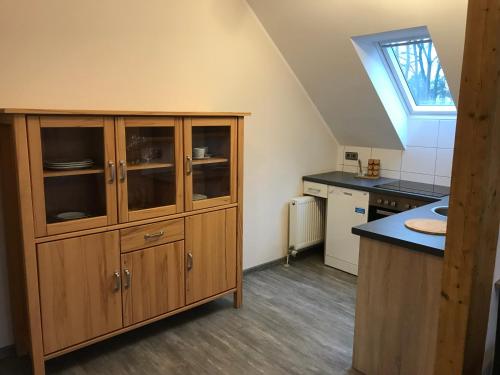 a kitchen with a large wooden cabinet and a sink at Apartment-Pension Schwalbennest in Herzogenaurach